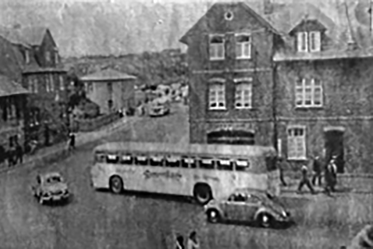 Das DMV-Haus in der Nachkriegszeit (hinter dem Bus). An der Ecke im kleinen Ladengeschäft befand sich eine Apotheke. De rBus biegt in die Hermannsteiner Str. ein.